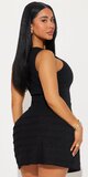 Rebrované mini šaty s vysokým výstrihom a volánovou sukňou v čiernej farbe